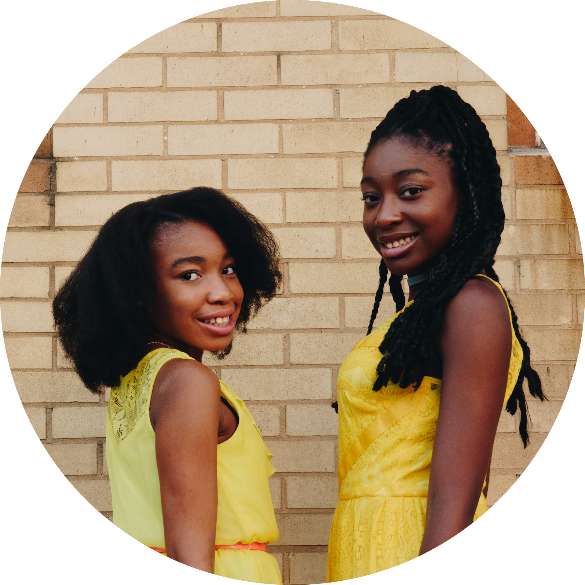 Two girls in yellow dresses smiling